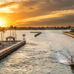 "Group of young adults enjoying a vibrant sunset at Miami Beach, one of the best places in Florida for young adults to vacation, showing a lively boardwalk scene with palm trees and beach activities."