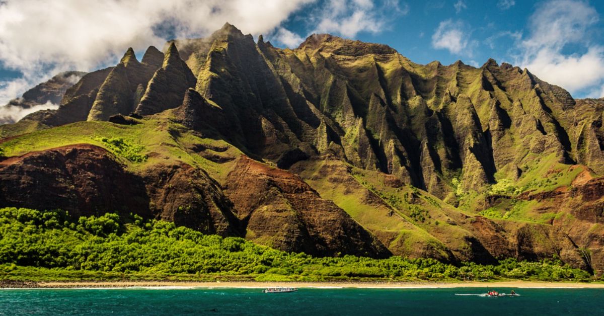 Scenic view of a tropical Hawaiian beach with turquoise waters, golden sand, lush palm trees, and majestic mountains in the background, capturing the essence of 'The Ultimate Hawaii Travel Guide'.